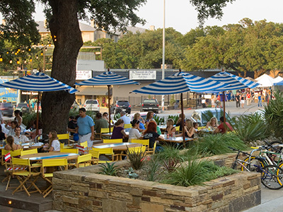 Outdoor seating area with shade from umbrellas and trees