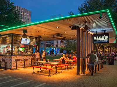 Twilight view of concessions booth with neon trim and seating area