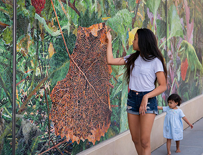 Woman and young girl getting a closeup view of a large wall mural