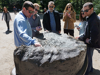 People exploring an interpretive model of the adjacent trail system.