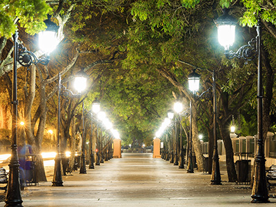 Wide sidewalk extends into the distance, lit by a row of street lights on either side