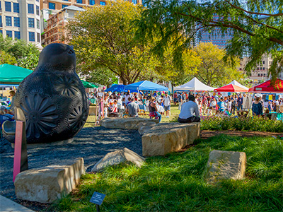 Sunny day at the park with booths along the walkway