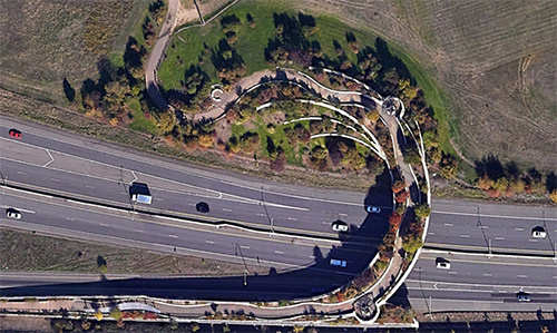 Precedent aerial image of a well-designed pedestrian overpass, with vegetation and meandering paths.